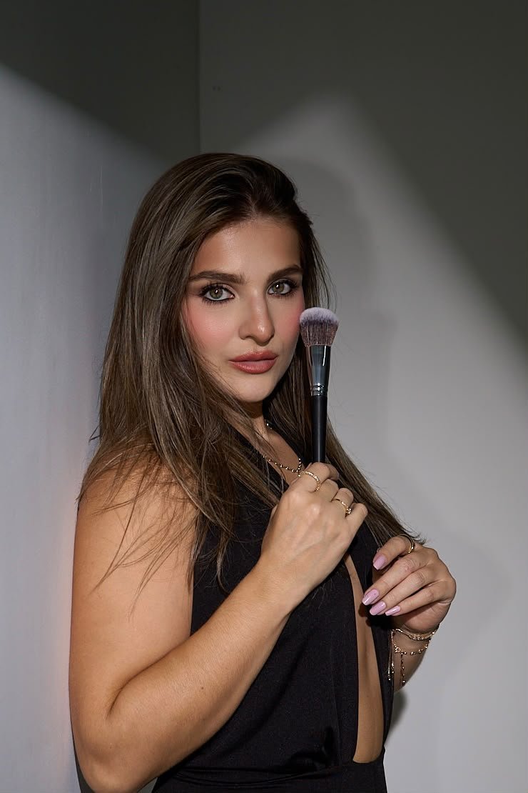 Valentina Zuluaga, professional makeup artist in Medellín, holding a makeup brush